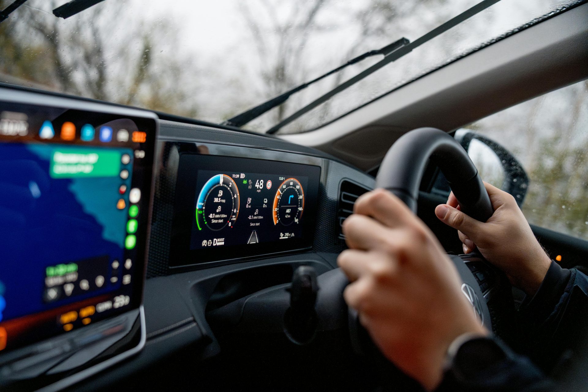 Person driving a car with modern dashboard and GPS navigation system.