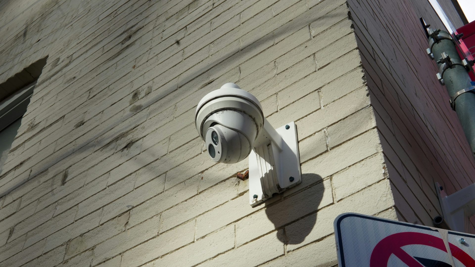Security camera mounted on a brick wall.